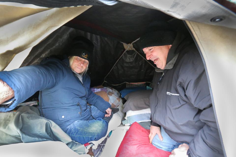 Tami Sandler, 64 and her husband Jeff, 55, show the tiny space they share in their tent in the woods where they have been living for 10 months.