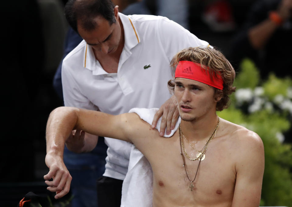 Alexander Zverev of Germany receives medical attention during his quarter-final match against Russia's Karen Khachanov at the Paris Masters tennis tournament at the Bercy Arena in Paris, France, Friday, Nov. 2, 2018. (AP Photo/Christophe Ena)