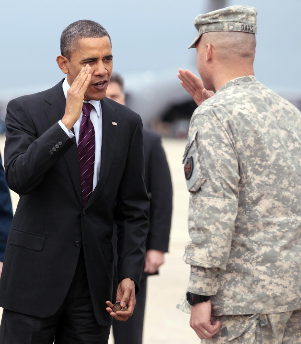 President Barack Obama greets troops as they step off a plane on the tarmac at Andrews Air Force Base, Md., Tuesday, Dec. 20, 2011, during a ceremony marking the return of the United States Forces-Iraq Colors and the end of the war in Iraq. (AP Photo/Carolyn Kaster)