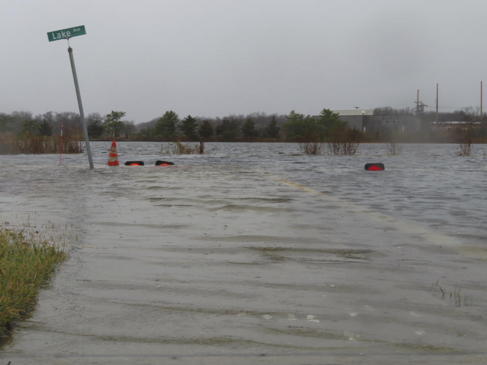 Lake Avenue in Bay Head, N.J. is flooded during a storm on Monday, Dec. 18, 2023 that sent Twilight Lake spilling into the roadway. Communities up and down the East Cast were dealing with flooding and high winds from the storm. (AP Photo/Wayne Parry)