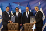 Israeli Prime Minister Naftali Bennett, second right, and Honduran President Juan Orlando Hernandez, second left, look on as Israeli Foreign Minister Yair Lapid, right, and Honduran Foreign Minister Lisandro Rosales hold signed agreements between their two countries at the prime minister's office, in Jerusalem, Thursday, June 24, 2021. (Heidi Levine/Pool via AP).