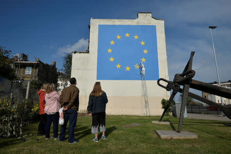 An artwork attributed to street artist Banksy, depicting a workman chipping away at one of the 12 stars on the flag of the European Union, is seen on a wall in the ferry port of Dover, Britain May 7, 2017. REUTERS/Hannah McKay