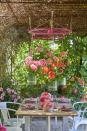 <p>Dine alfresco under a canopy of flowers with this DIY upcycling idea. Attach jute string to a pergola or similar structure, use old bicycle wheels to string it through, and hang easy-to-care-for geraniums in pots.</p>