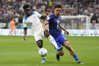 Antonee Robinson of the United States vies for the ball with England's Bukayo Saka, left, during the World Cup group B soccer match between England and The United States, at the Al Bayt Stadium in Al Khor , Qatar, Friday, Nov. 25, 2022. (AP Photo/Luca Bruno)