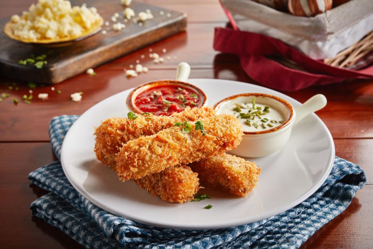 deep fried Mozzarella cheese sticks with tomato ketchup and mayo dip served in a dish isolated on wooden background side view