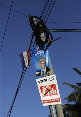 A light pole displays a poster of Norman Quijano (top), presidential candidate of the conservative Alianza Republicana Nacionalista (ARENA), and an election poster of El Salvador's ruling leftists Farabundo Marti Front for National Liberation (FMLN), in San Salvador February 1, 2014. REUTERS/Henry Romero