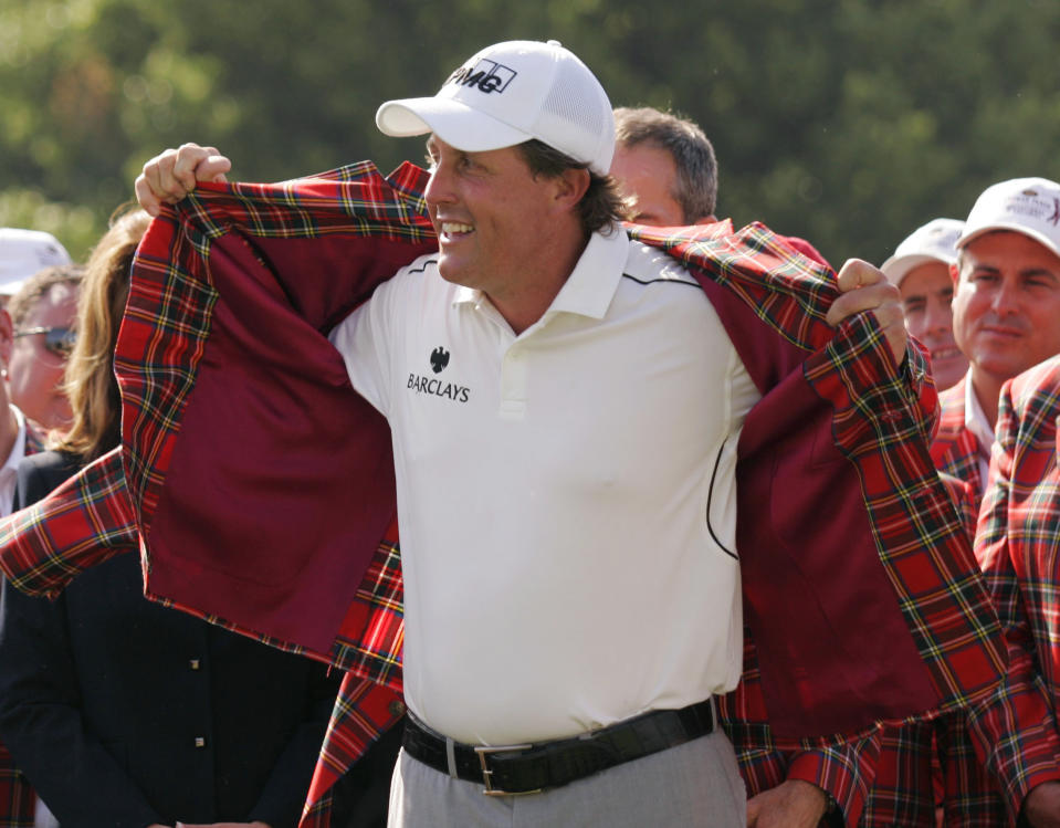 FILE - Phil Mickelson puts on the traditional red plaid jacket after winning the Colonial golf tournament in Fort Worth, Texas, in this Sunday, May 25, 2008, file photo. The Colonial begins Thursday, May 27, 2021, and is expected to be two-time Colonial champion Phil Mickelson's final tournament before his hometown U.S. Open. (AP Photo/Donna McWilliam, File)