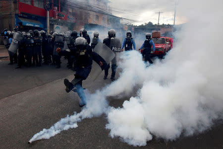 A riot policeman kicks a tear gas canister to demonstrators, during a protest against the re-election of Honduras' President Juan Orlando Hernandez in Tegucigalpa Honduras January 20, 2018. REUTERS/Jorge Cabrera