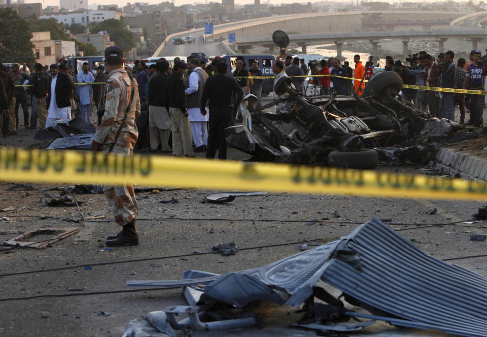 Police cordon off the area of bombing in Karachi, Pakistan, Thursday, Jan. 9, 2014. Police said a car bomb has killed a senior police investigator known for arresting dozens of Pakistani Taliban, as well as two other officers. (AP Photo/Shakil Adil)
