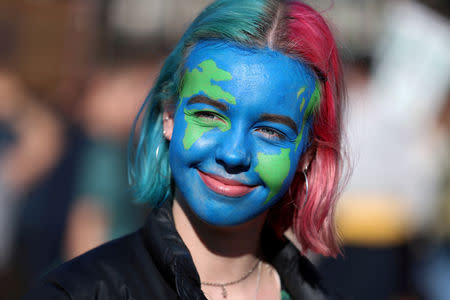A girl looks on as people take part in a "youth strike for climate change" demonstration in London, Britain February 15, 2019. REUTERS/Simon Dawson TPX IMAGES OF THE DAY