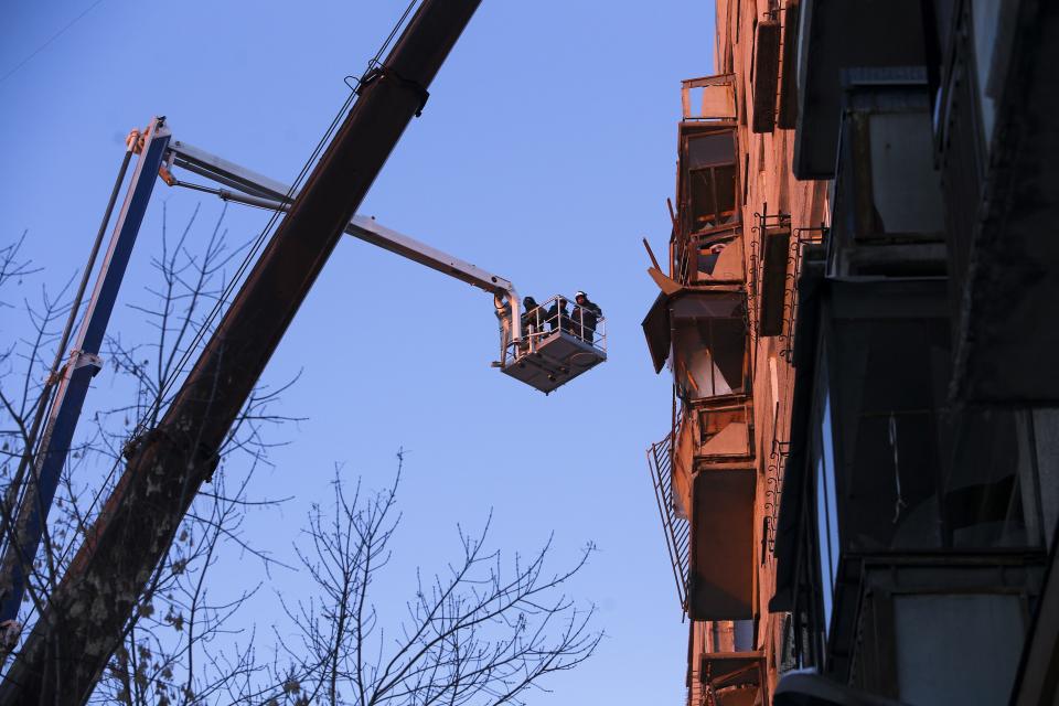 Emergency Situations employees working at the scene of a collapsed apartment building in Magnitogorsk, a city of 400,000 people, about 1,400 kilometers (870 miles) southeast of Moscow, Russia, Monday, Dec. 31, 2018. At least four people died Monday when sections of an apartment building collapsed after an apparent gas explosion in Russia's Ural Mountains region, officials said, and hundreds of rescuers are searching for survivors under the debris. (AP Photo/Maxim Shmakov)