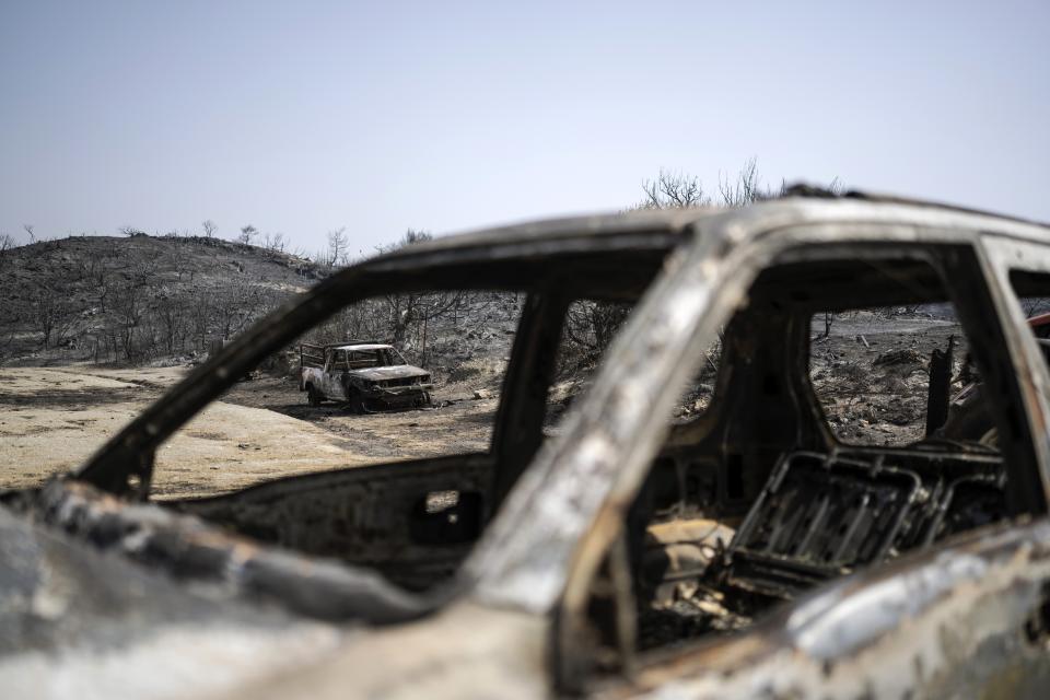 Burnt cars are seen after a wildfire near Gennadi village, on the Aegean Sea island of Rhodes, southeastern Greece, on Thursday, July 27, 2023. The wildfires have raged across parts of the country during three successive Mediterranean heat waves over two weeks, leaving five people dead. (AP Photo/Petros Giannakouris)