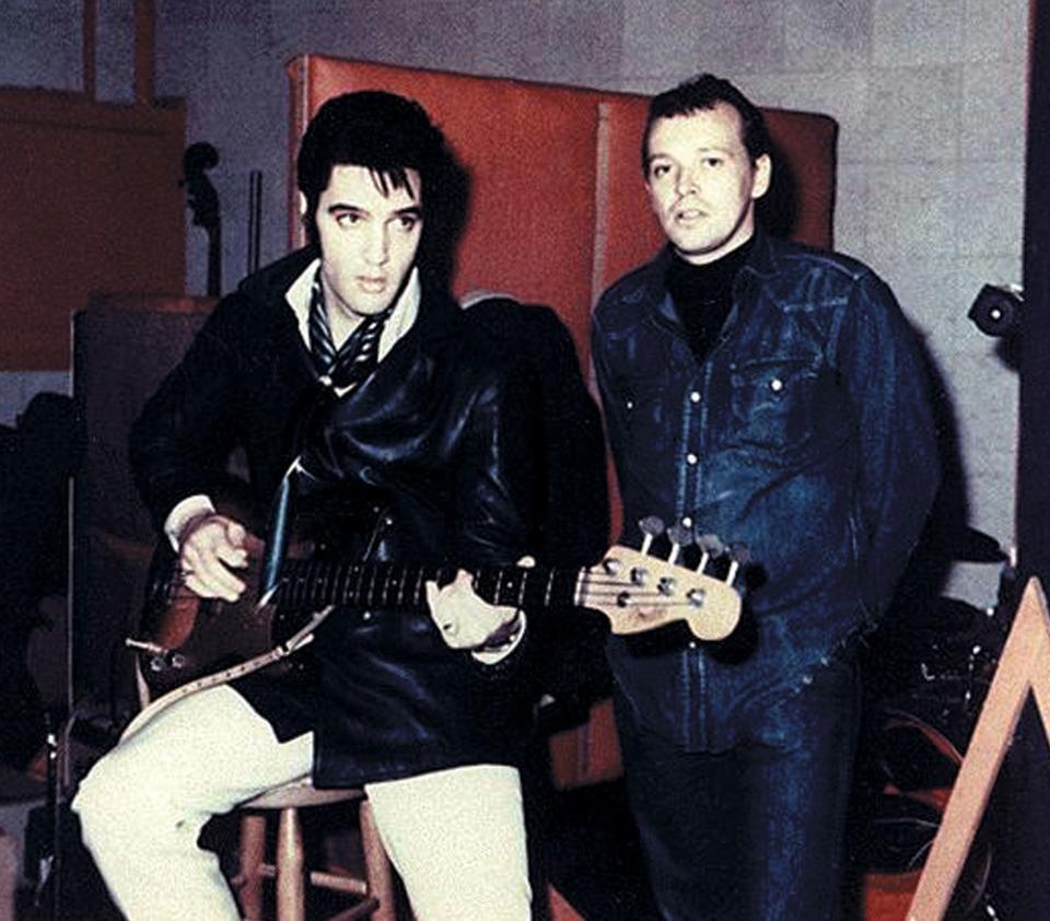 Elvis Presley holds a guitar with Chips Moman standing at American Sound Studio in Nashville, Tennessee.