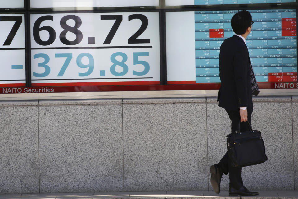 A man looks at an electronic stock board of a securities firm in Tokyo, Thursday, Nov. 21, 2019. Shares skidded Thursday in Asia after moderate declines on Wall Street as anxious mounted over the possibility the U.S. and China may not reach a trade deal before next year. (AP Photo/Koji Sasahara)