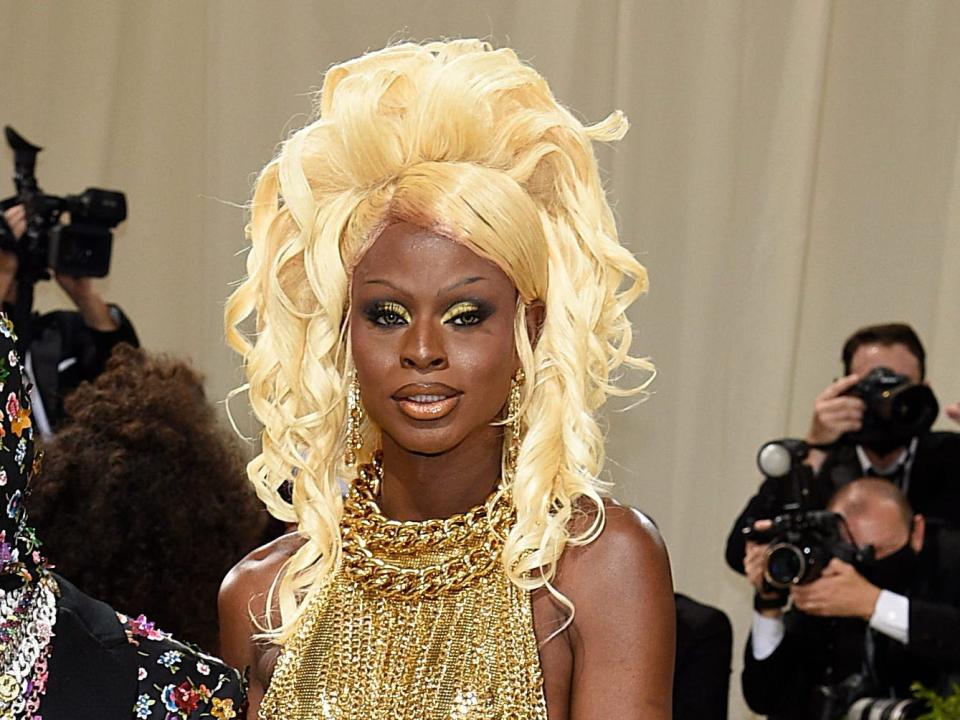 Symone at the met gala on the right wearing a gold gown.