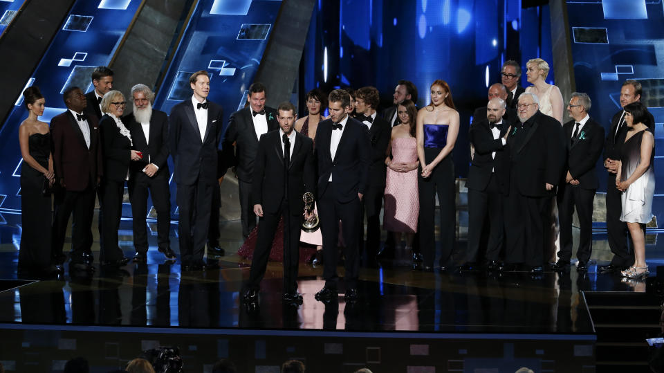 Writers D.B. Weiss (L) and David Benioff, with cast and crew, accept the award for Outstanding Drama Series for HBO's "Game of Thrones" at the 67th Primetime Emmy Awards in Los Angeles, California September 20, 2015.  REUTERS/Lucy Nicholson