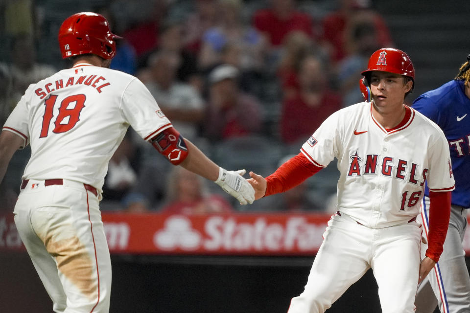 Los Angeles Angels' Mickey Moniak, right, celebrates with Nolan Schanuel after scoring off a single hit by Anthony Rendon during the seventh inning of a baseball game against the Texas Rangers, Monday, July 8, 2024, in Anaheim, Calif. (AP Photo/Ryan Sun)