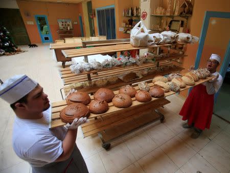 Men with special needs hold bread in the southern city of Tyre, Lebanon December 18, 2018. Picture taken December 18, 2018. REUTERS/Ali Hashisho