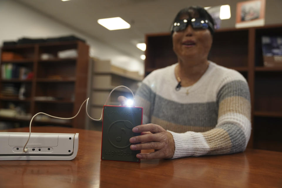 Minh Ha, gerente de tecnología de asistencia en la Escuela para los Ciegos Perkins, prueba un dispositivo LightSound por primera vez en la biblioteca de la escuela en Watertown, Massachusetts, el 2 de marzo de 2024. (AP Foto/Mary Conlon)
