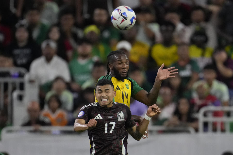 Jamaica's Kasey Palmer, top, and Mexico's Orbelin Pineda jump for a header during a Copa America Group B soccer match in Houston, Texas, Saturday, June 22, 2024. (AP Photo/David J. Phillip)