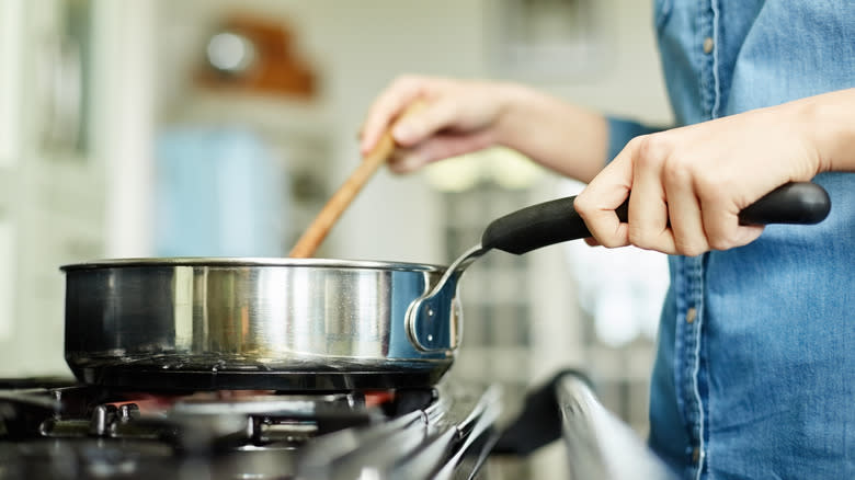Person stirring on stove