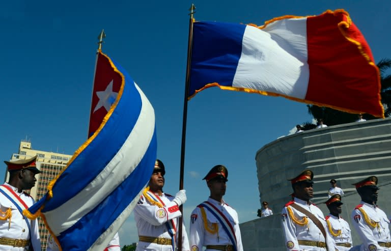 Cuban honor guards flutter French and Cuban flags during a wreath laying ceremony at the "Jose Marti" Memorial in Revolution Square in Havana on May 11, 2015, during French President Francois Hollande's visit