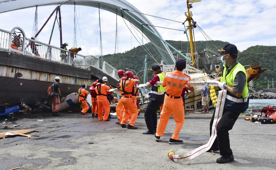 Rescue workers trying to free people trapped under the collapsed bridge in Taiwan.