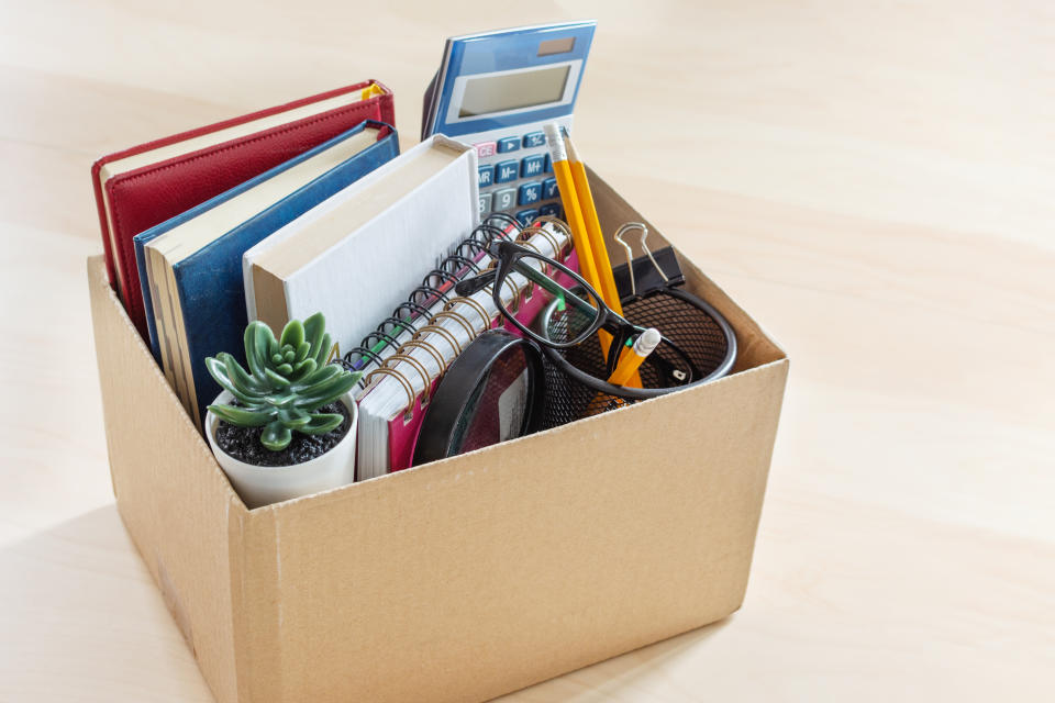 Cardboard box with office suplies on the desk. Dismissal of employment and resignation concept. Bankruptcy and economy crisis.