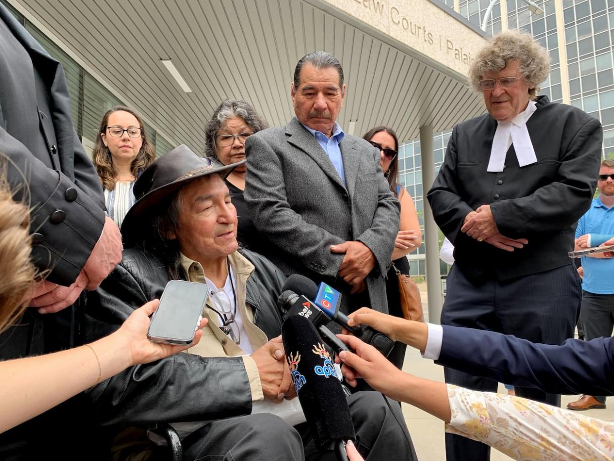 From left to right: Newly acquitted Allan Woodhouse and Brian Anderson, along with James Lockyer, one of the lawyers for the two men and director of Innocence Canada, speak to the media outside the Winnipeg Law Courts last July. (Brittany Hobson/The Canadian Press - image credit)