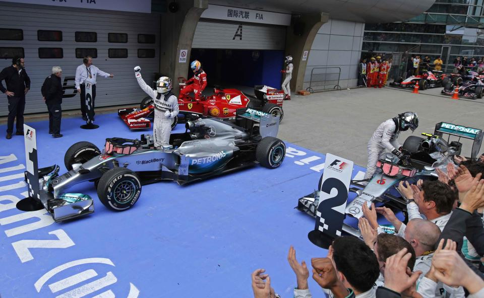 Mercedes Formula One driver Lewis Hamilton of Britain (C) gestures as he stands in his car to celebrate his win after the Chinese F1 Grand Prix at the Shanghai International Circuit April 20, 2014. REUTERS/Carlos Barria (CHINA - Tags: SPORT MOTORSPORT F1)