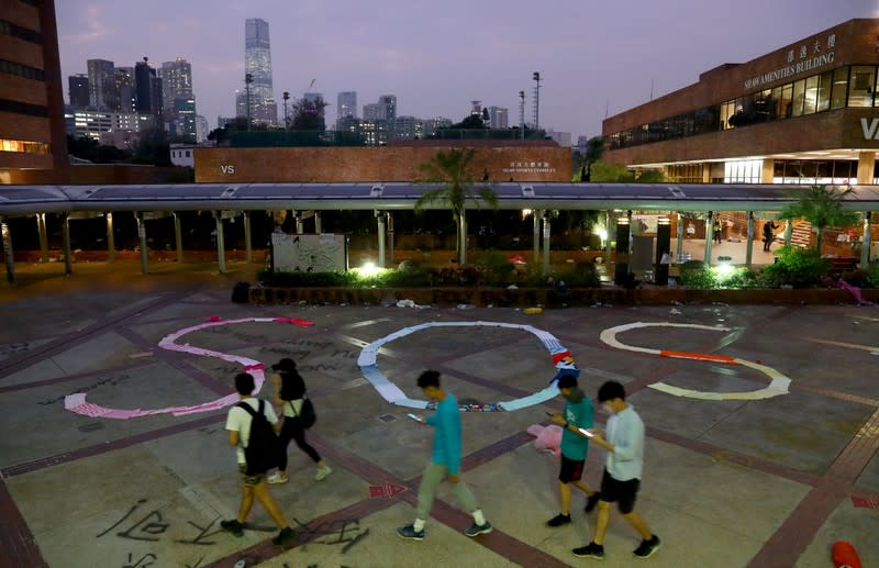 People pass by an "SOS" sign written with clothes on the campus of the Hong Kong Polytechnic University