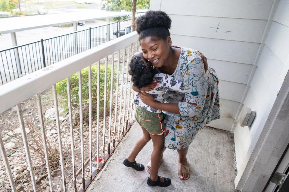 Aaliyah Gaulmon and Kourtni Chambers, 4, hug at their home. They were homeless when they came to Central Texas after the death of Kourtni's father.
