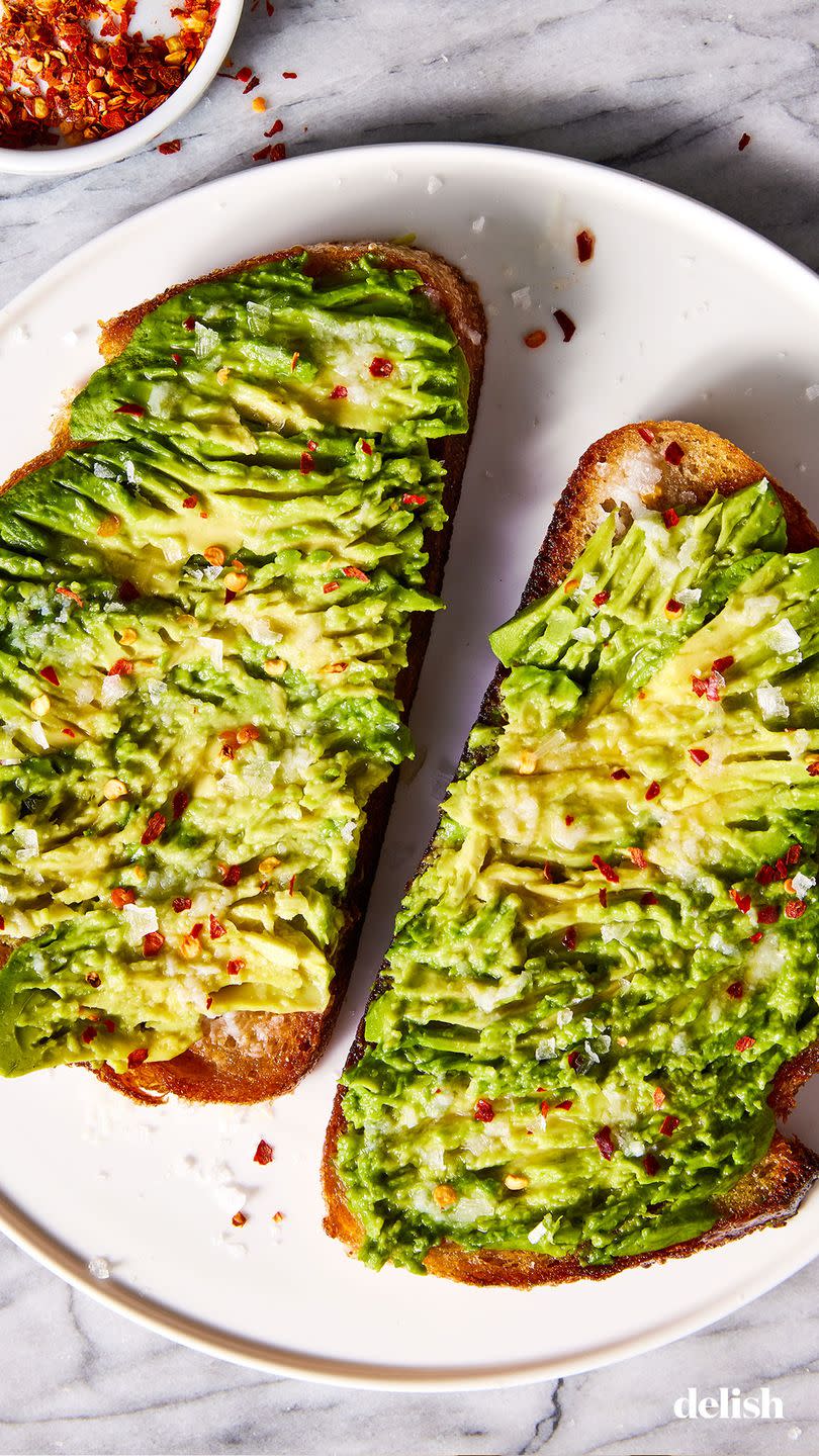 olive oil toasted whole wheat sourdough bread topped with ripe avocado, garlic, lemon juice, and red pepper flakes