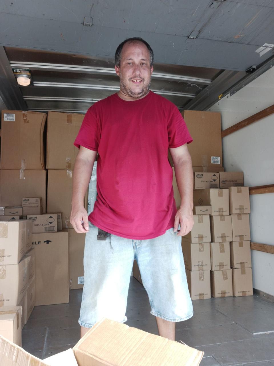 New Bedford resident Anthony Lessa Jr. is seen in the back of one of the moving trucks being loaded with supplies.