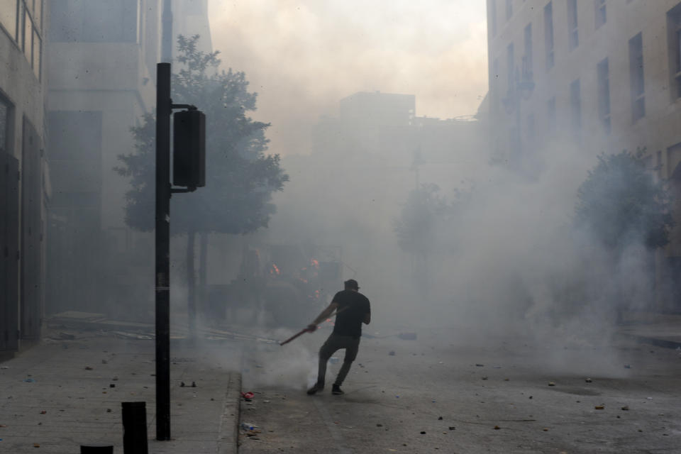 People clash with police during a protest against the political elites and the government after this week's deadly explosion at Beirut port which devastated large parts of the capital and killed more than 150 people, in Beirut, Lebanon, Saturday, Aug. 8, 2020. (AP Photo/Hassan Ammar)