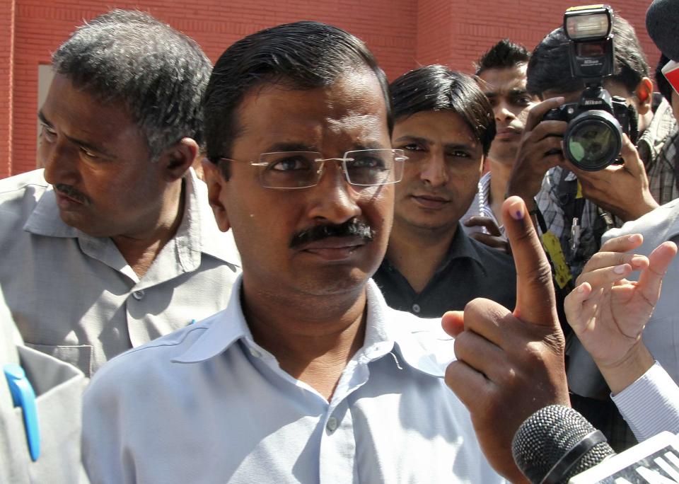 Arvind Kejriwal, the leader of the anti-corruption AAP, shows his ink-marked finger after casting his vote outside a polling station in New Delhi