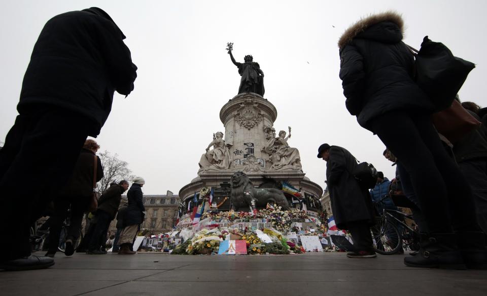 People pay tribute to the victims of Paris attacks at the Place de la Republique in Paris, France, November 27, 2015 as French President called on all French citizens to hang the tricolour national flag from their windows on Friday to pay tribute to the victims of the Paris attacks during a national day of homage. (REUTERS/Eric Gaillard)