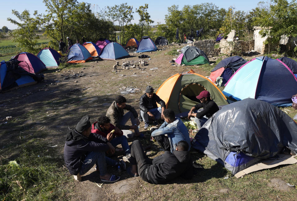 Migrants rest at a makeshift camp near a border line between Serbia and Hungary, near village of Horgos, Serbia, Thursday, Oct. 20, 2022. Located at the heart of the so-called Balkan route, Serbia recently has seen a sharp rise in arrivals of migrants passing through the country in search of a better future in the West. (AP Photo/Darko Vojinovic)