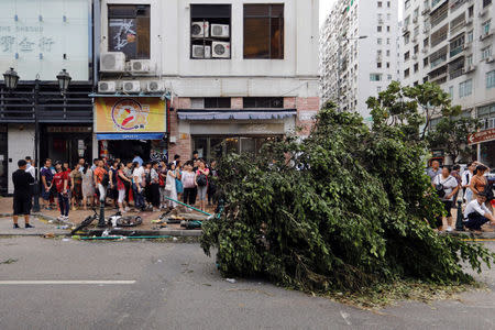 Tourists from China lineup outside a jewelry shop where a tree was uprooted by strong winds from Typhoon Hato in Macau, China August 24, 2017. REUTERS/Tyrone Siu