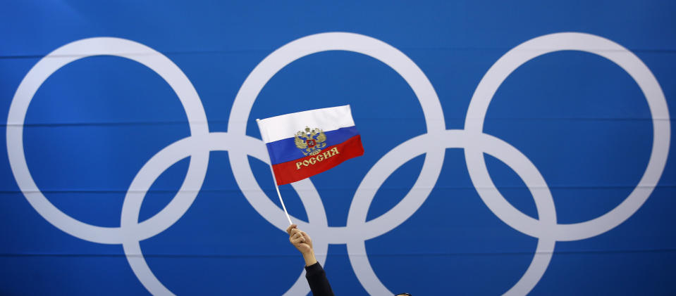 FILE - In this Wednesday, Feb. 21, 2018 file photo a fan waves a flag of Russia before the quarterfinal round of the men's hockey game between Norway and the team from Russia at the 2018 Winter Olympics in Gangneung, South Korea. The ruling on whether Russia can keep its name and flag for the Olympics will be announced on Thursday Dec. 17, 2020. The Court of Arbitration for Sport said Wednesday that three of its arbitrators held a four-day hearing last month in the dispute between the World Anti-Doping Agency and its Russian affiliate, known as RUSADA. (AP Photo/Jae C. Hong, File)