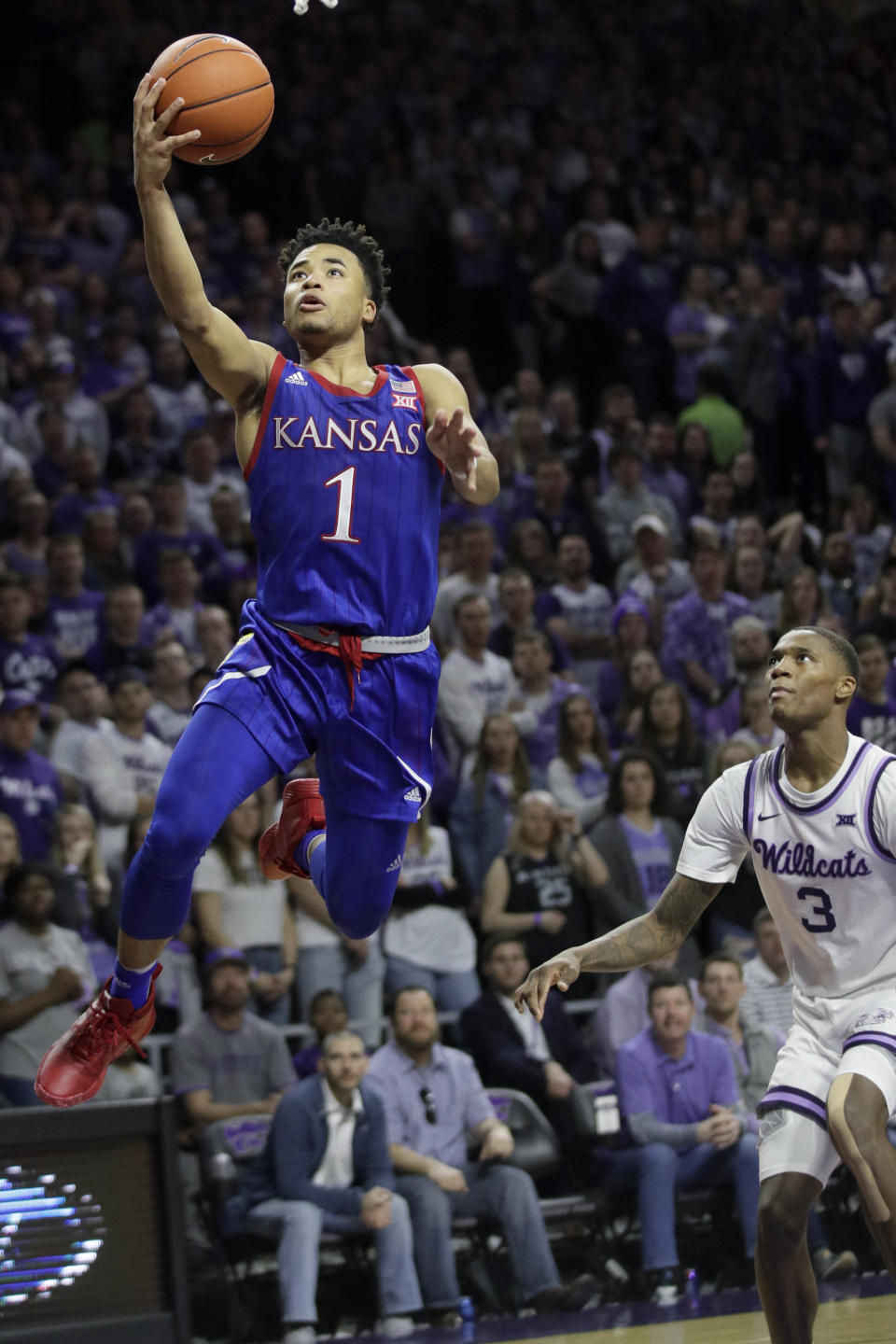 Kansas guard Devon Dotson (1) makes a basket in front of Kansas State guard DaJuan Gordon (3) during the first half of an NCAA college basketball game in Manhattan, Kan., Saturday, Feb. 29, 2020. (AP Photo/Orlin Wagner)