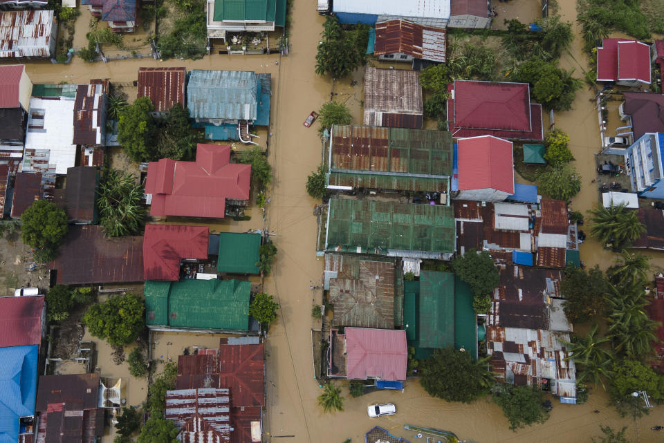In this image taken with a drone, vehicles pass by a flooded road due to Typhoon Noru in San Miguel town, Bulacan province, Philippines, Monday, Sept. 26, 2022. Typhoon Noru blew out of the northern Philippines on Monday, leaving some people dead, causing floods and power outages and forcing officials to suspend classes and government work in the capital and outlying provinces. (AP Photo/Aaron Favila)