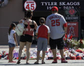 Mourners stand at a memorial to give their condolences for Los Angeles Angels pitcher Tyler Skaggs at Angel Stadium in Anaheim, Calif., Tuesday, July 2, 2019. The 27-year-old left-hander died in his Texas hotel room, where he was found unresponsive Monday afternoon. (AP Photo/Chris Carlson)