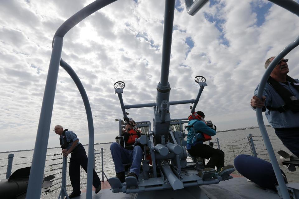 CORRECTS BOAT NUMBER TO 305, NOT 105 - Members of the media sit on a gun turret during a media ride Thursday, March 16, 2017, on the PT 305, which was restored by the National WWII Museum, on Lake Pontchartrain, where she was originally tested by Higgins Industries more than 70 years ago, in New Orleans, Thursday, March 16, 2017. The U.S. Navy PT boat that sank three vessels and saw action in Europe in World War II is back in New Orleans where it was built, what historians describe as the nation's only fully restored combat ship of that type from the era. Its return to water is the culmination of a 10-year restoration project by the museum. (AP Photo/Gerald Herbert)