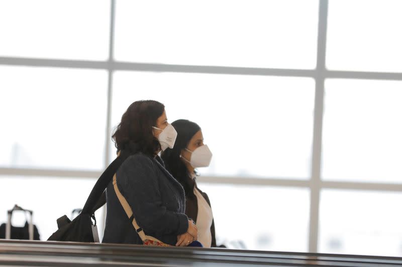 Travelers wear masks in John F Kennedy International Airport in New York