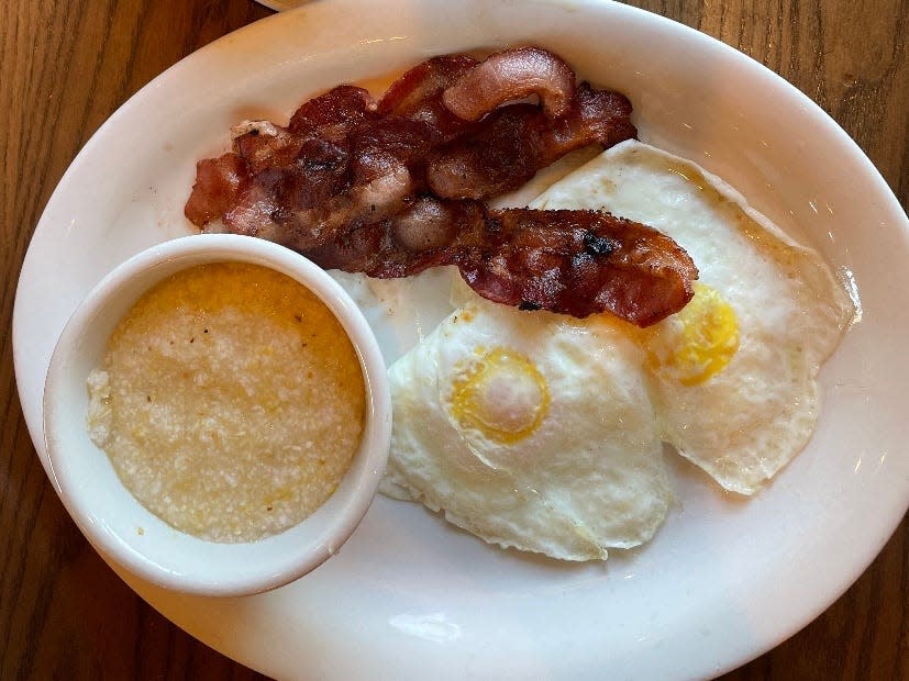 Plate of grits, over-easy eggs, and bacon