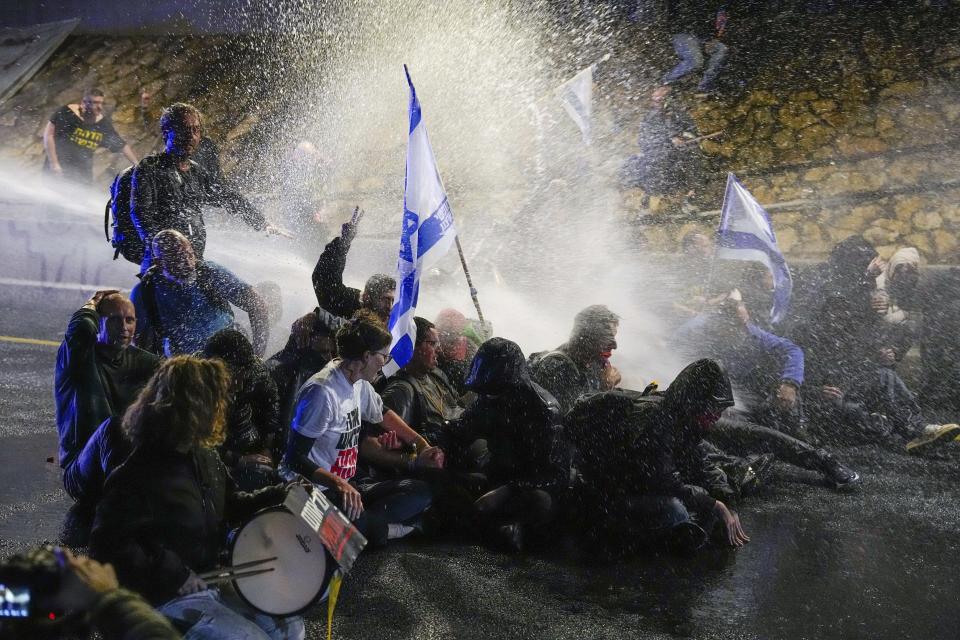 Police use water cannon to disperse demonstrators during a protest against Israeli Prime Minister Benjamin Netanyahu's government, and calling for the release of hostages held in the Gaza Strip by the Hamas militant group, in Tel Aviv, Israel, Saturday, March 9, 2024. (AP Photo/Ariel Schalit)