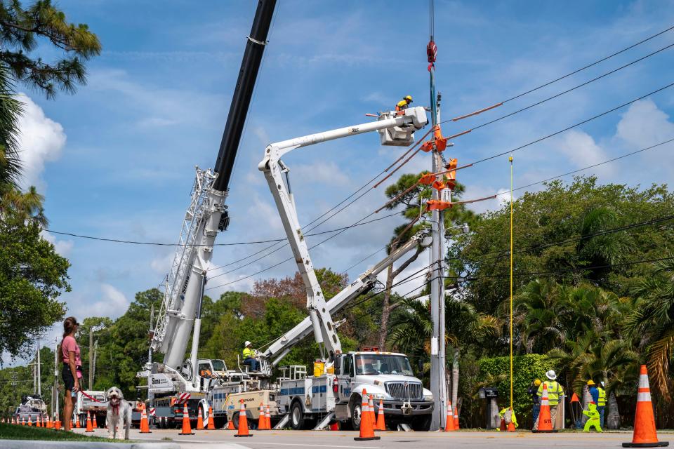 FPL crews replace a wooden feeder pole with a concrete one along Roebuck Road in Jupiter, Florida on April 27, 2022.