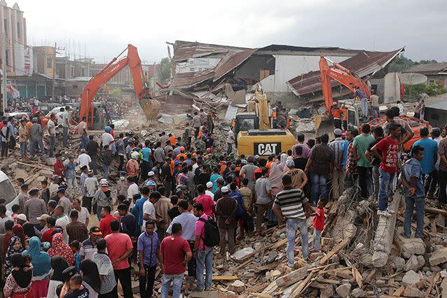 Rescues work to pull survivors from  the rubble. Source: AP