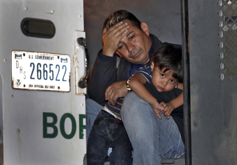 FILE - In this July 18, 2018, file photo, a father and his 3-year-old son are detained in the back of a U.S. Customs and Border Patrol vehicle on July 18, 2018, in San Luis, Ariz. The boy, his father and two siblings were arrested by a U.S. Border Patrol agent who spotted them crossing a canal along the the international border. (AP Photo/Matt York, File)